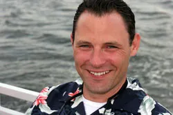 Man smiling, relaxing on a sail boat